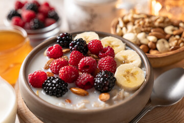 Oatmeal with fresh berries, nuts, and banana fruit. Healthy food concept. - 647613948