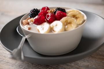 Oatmeal with fresh berries, nuts, and banana fruit. Healthy food concept. - 647613989