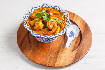 Crevettes curry. Spécialité asiatique sur une assiette en bois.