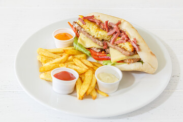 Doner kebab sandwich à la viande avec les lardons sur une assiette avec des frites et sauces. 