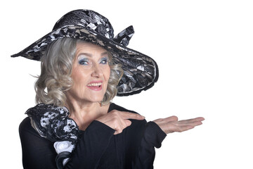 Happy gorgeous mature woman in hat showing something