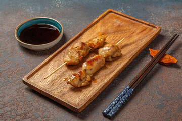 Yakitori japonais au poulet sur un plateau en bois avec une sauce soja. Brochette de viande. 