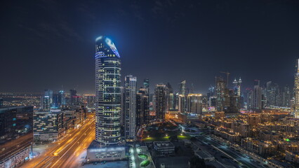 Panorama showing Dubai Downtown and business bay night timelapse with tallest skyscraper and other towers - obrazy, fototapety, plakaty