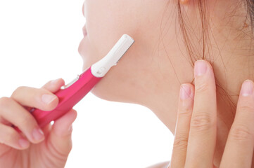 顔のムダ毛を電動トリマーで処理する女性