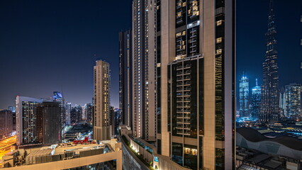 Tallest skyscrapers in downtown dubai located on bouleward street near shopping mall aerial night...