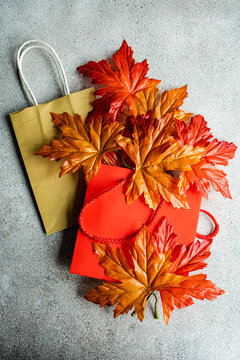 Overhead view of Red autumn maple leaves on top of two blank paper shopping bags