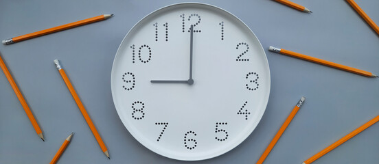 Banner with clock. 9 o'clock, morning. Study time. Back to school. Watch with white clock face on blue table background with pencils. New day. Beginning of week. Header for website, article, shop.