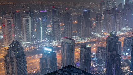 JLT skyscrapers and Dubai marina near Sheikh Zayed Road aerial all night timelapse. Residential buildings