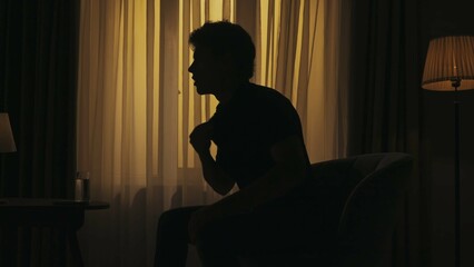 Everyday life creative concept. Man sitting on a chair in the heated living room, cooling under air...