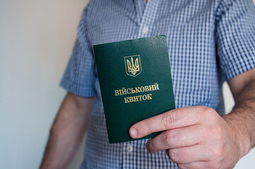 Translation: "military id". Civil man in shirt with army document for rookie, veteran, soldier in hand on white background