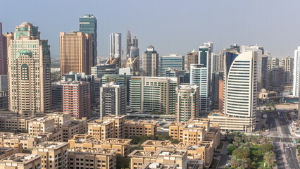 Fototapeta na wymiar Skyscrapers in Barsha Heights district and low rise buildings in Greens district aerial all day timelapse. Dubai skyline
