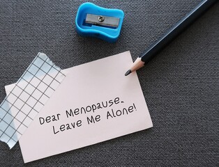 Pencil wrote on a card Dear Menopause Leave me alone! concept of middle aged women dealing or...