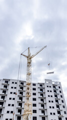Fototapeta na wymiar A tower crane on the construction of a multi-storey residential building