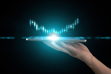 investment and finance concept, businessman holding virtual trading graph and blurred light on...