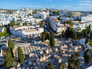 Aerial view landscape, drone view of town, white houses, cemetery and green surroundings. Portugal Algarve.