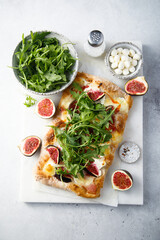 Homemade pizza with figs and arugula