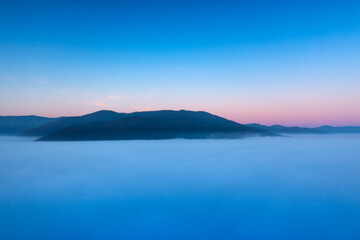 Misty Mountain Sunrise: A Silhouetted Landscape