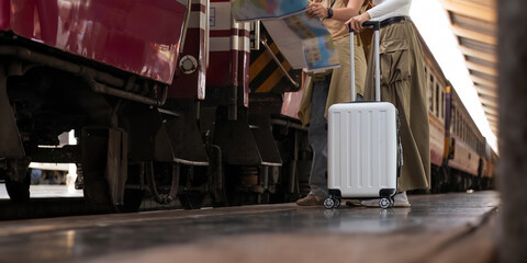 Two female tourist go on a trip traveling . look at the map and walking with luggage at train station. lifestyle active journey and travel lifestyle concept transport