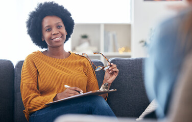 Psychologist on couch, writing notes with patient, advice and help in psychology, listening and...