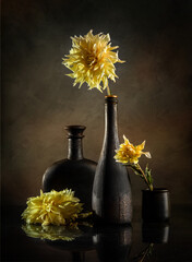 Modern still life with yellow dahlias in black vases on a dark background © 02irina