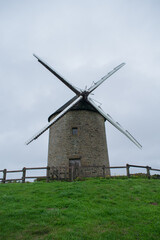 Molino de viento sobre pradera verde en Normand&iacute;a