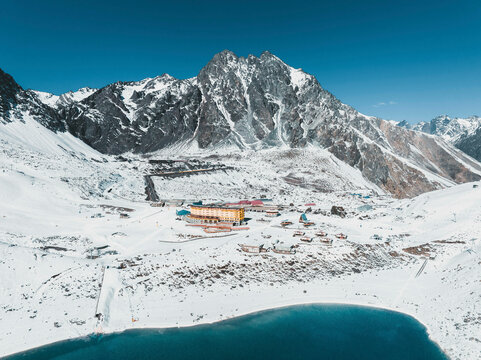 Aerial View Of Portillo Ski Lodge Surrounded By Snow Capped Mountains And Laguna Del Inca In The Chilean Andes, Chile.