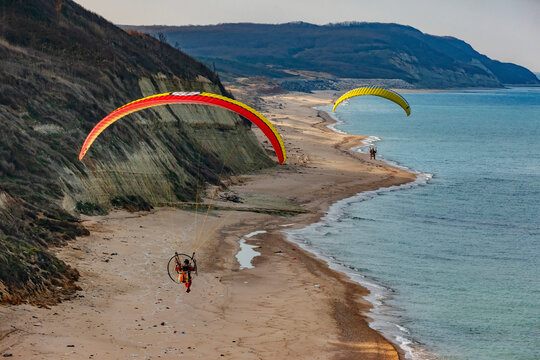 Aerial view of two paramotor pilots flying over natural beach at the Black Sea coast of Istanbul, Turkey.