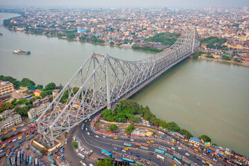 Aerial view of architectural landmark Howrah bridge or Rabindra Setu over the Hooghly River at day in Kolkata, West Bengal, India.