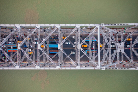 Aerial view of architectural landmark Howrah bridge or Rabindra Setu over the Hooghly River at day in Kolkata, West Bengal, India.