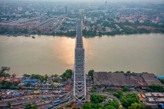 Aerial view of architectural landmark Howrah bridge or Rabindra Setu over the Hooghly River at day in Kolkata, West Bengal, India.