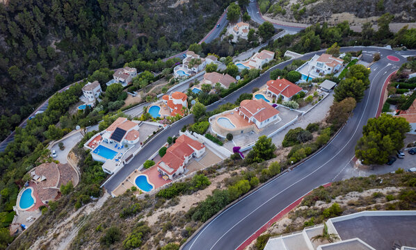 Aerial view of holiday villas with pools in a residential area, Zona Encinas, Cumbre del Sol, Alicante, Spain.