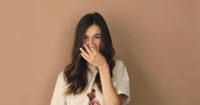 Disgusting odor. Discontent brunette curly woman frowning face, smells something awful, feeling aversion, beige studio background. Girl face with aversion dislikes something unpleasant.