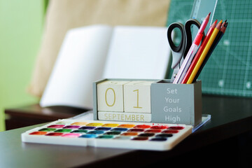 September 1. Image of september 1 wooden calendar on desktop. Autumn day. Back to school. Pencils and paints, stationery