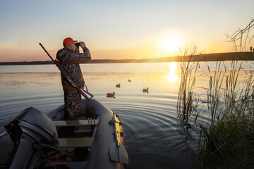 hunter with shotgun hunting of ducks. duck hunting at sunrise.