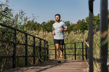 Fast running in the park and fitness exercises for cardio and sportswear T-shirt. Man interval training sports lifestyle. Slender figure of a man jogging.