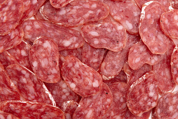 heap of salami sausage, slices of salami as background