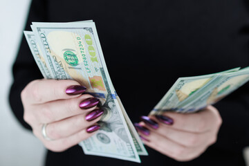 woman's hands holding American dollar paper bills