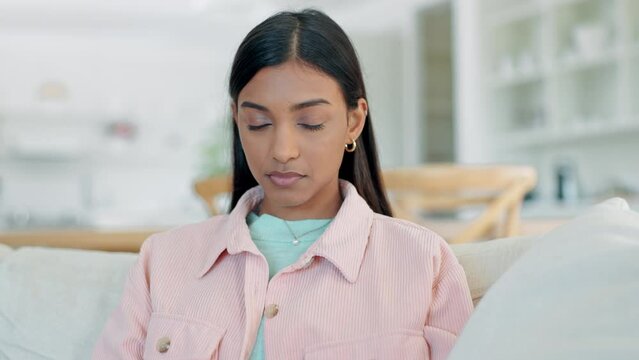 Woman, face and frustrated on living room sofa with annoyed expression from conflict, problem or mental health. Indian person, angry and rolling eyes emoji from depression or disappointed and upset