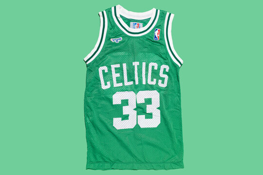 Boston Celtics retro green basketball jersey with Larry Bird's number 33, on a green background. Basketball, spalding, sports equipment and basketball legend.