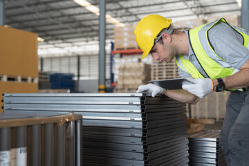 Metalwork manufacturing, warehouse of raw materials. Male warehouse worker inspecting quality...