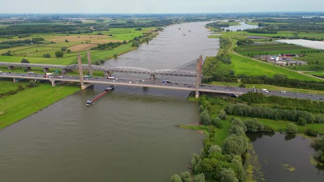 High angle Drone Point of View on Cargo Ship sailing on the Waal River in Zaltbommel, Gelderland, The Netherlands on summer day.