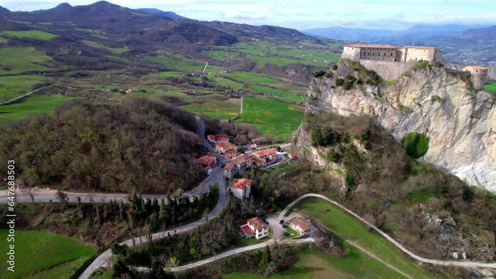 Wall mural Unique beautiful places of Italy. Emilia Romagna region. Aerial drone view of impressive San Leo medieval castle located in the top of sandstone rock and village
