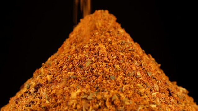 Zoom frame sprinkle dry seasoning, black background. Natural seasoning for chicken cooking