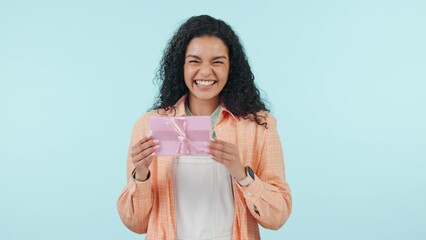 Woman, shake gift box and surprise, birthday and celebration with event isolated on blue background. Mockup space, party and present, excited with giveaway or prize in studio, curious about reward