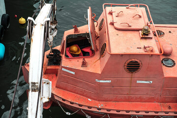 old rusty ship lifeboat, resque training stcw on vessel, seafarer education, orange safety boat, davit launched liferaft onshore