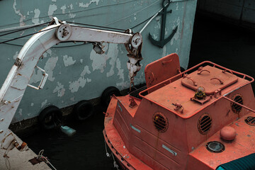 old rusty ship lifeboat, resque training stcw on vessel, seafarer education, orange safety boat, davit launched liferaft onshore