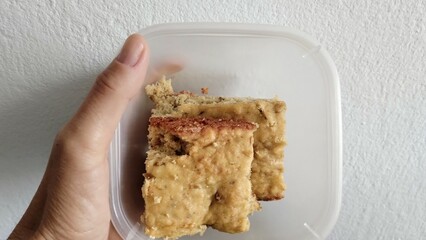 hand holding a bowl of cake