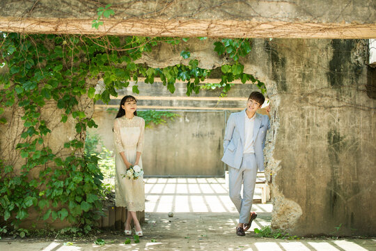 A loving couple is taking wedding photos outdoors for their wedding.