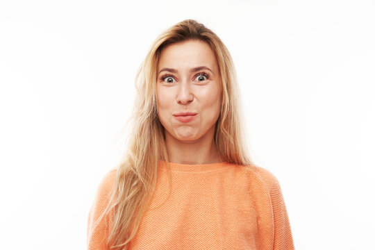 Portrait of young blond woman puffing cheeks with funny face isolated on white studio background. Humor concept, mouth inflated with air crazy expression.