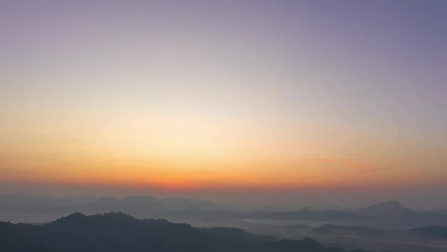 aerial hyperlapse view amazing colorful in the pink sky at dawn over the misty sea in the valley. .colorful sky at twilight above the mountain range. .Mist covers the complicated mountain ranges.